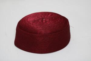 A maroon-colored hat with an embroidered design on top. photo