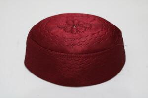 Red patterned hat with a flower design on top. photo