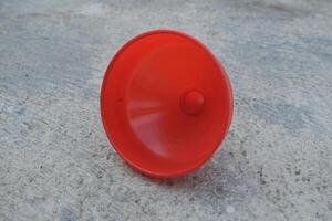 Red plastic funnel on a concrete surface. photo