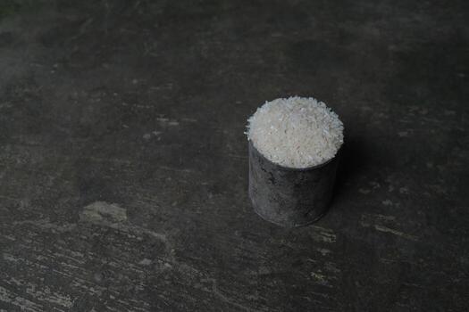 White rice in a metal container on a rustic surface. photo