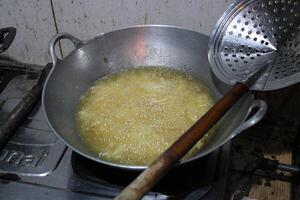 Food being fried in a pan with hot oil and bubbles. photo