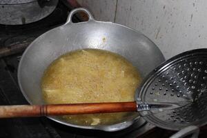 Food being deep-fried in a large pot with oil and bubbles. photo