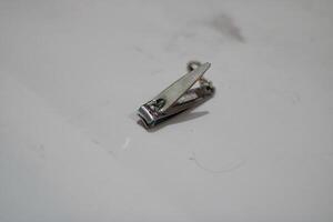 Close-up of a silver nail clipper on a white background. photo