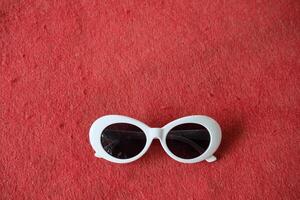 White sunglasses on a red background. photo