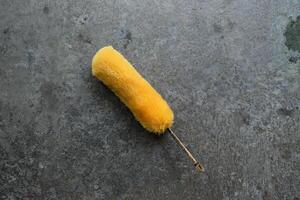 Yellow duster on a concrete floor. photo