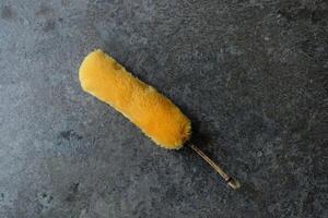Yellow duster on a textured gray background. photo