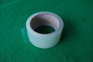 Clear packing tape roll on green background. photo