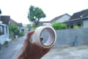Hand holding a roll of clear tape. photo