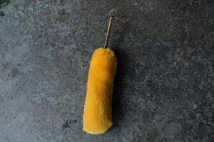 Yellow duster against a grey background. photo