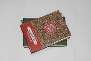 A close-up of a Quran on top of a book. photo