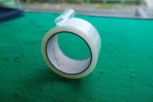 Close-up of transparent adhesive tape on green surface. photo