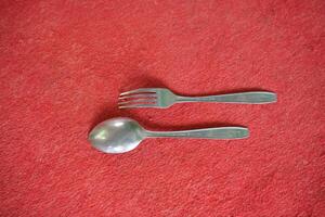 A silver fork and spoon on red felt. photo