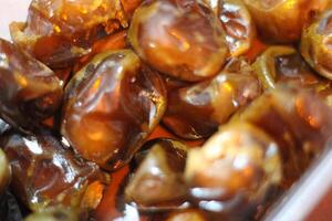 Close-up of dates in a bowl, glistening and golden brown. photo