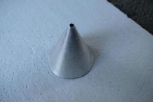Closeup of a metal cone on a white textured background. photo
