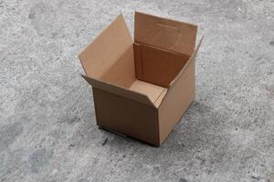Open cardboard box on concrete surface. photo