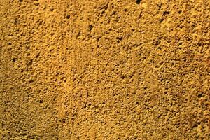 Close-up texture of a rough, golden wall. photo