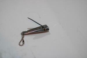 Silver nail clippers with a chain isolated on a white background. photo