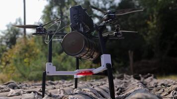 Drone with a warhead for military purposes. Close-up of a drone equipped with a cylindrical warhead and an attached payload. Drone equipped with various mounted hardware, including a cylindrical video