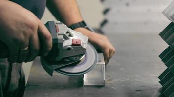 Worker grinding metal piece in a workshop. A close-up of a worker using an electric grinder on a metal piece in a workshop. video