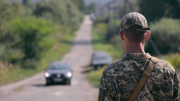 A soldier of the Ukrainian army meeting a car to cross a roadblock video