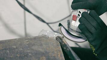 Grinding metal surface with power tool. A close-up shot of a worker grinding a metal surface using a handheld power tool. video