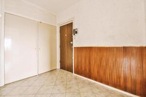 A hallway with a door and a wooden paneled wall photo