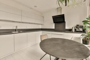 A kitchen with a table and chairs in it photo