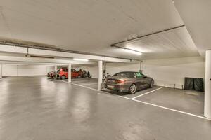 An empty parking garage with two cars parked in it photo