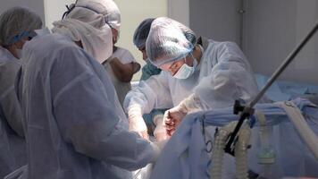 A team of surgeons working together in a modern operating room during a complex procedure. The photo highlights the advanced medical equipment and the focused collaboration of the surgical team video