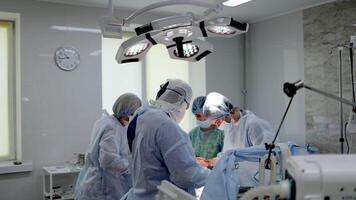A team of surgeons working together in a modern operating room during a complex procedure. The photo highlights the advanced medical equipment and the focused collaboration of the surgical team video