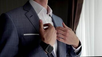 Close up view of unrecognizable man adjusts his suit. Business man put suit on during morning routine at home, preparing to go to work video