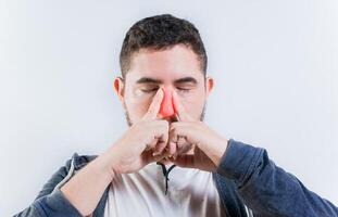 Sore person suffering with nasal bridge on isolated background. Suffering man with nasal congestion photo
