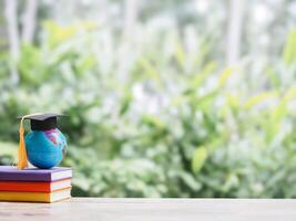 Student creative desktop , earth globe with graduation hat on hardcover book. Copy space for text, Back to school, Education concept photo