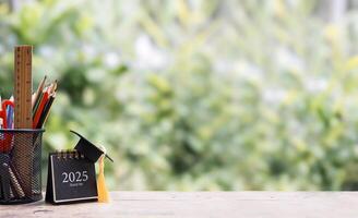 Student creative desktop, colorful stationery and 2025 desk calendar with graduation hat. Copy space for text, Back to school, Education concept photo