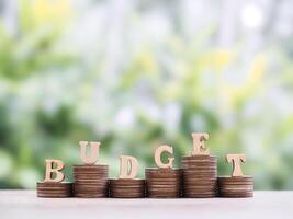 Wooden blocks with the word BUDGET on stack of coins. The concept about budget planning and allocation photo