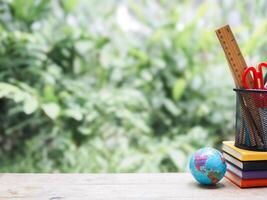 Student creative desktop with colorful stationery on hardcover book and earth globe. Copy space for text, Back to school, Education concept photo