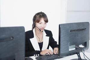 call center smiling business operator customer support team phone services agen working and talking with headset on desktop computer at call center photo