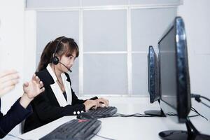call center smiling business operator customer support team phone services agen working and talking with headset on desktop computer at call center photo