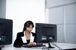 call center smiling business operator customer support team phone services agen working and talking with headset on desktop computer at call center photo