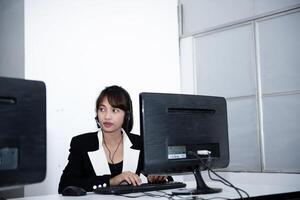 call center smiling business operator customer support team phone services agen working and talking with headset on desktop computer at call center photo