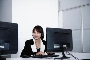 call center smiling business operator customer support team phone services agen working and talking with headset on desktop computer at call center photo