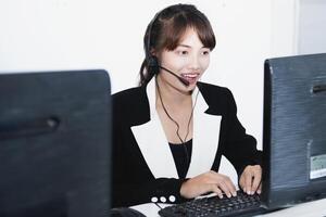 call center smiling business operator customer support team phone services agen working and talking with headset on desktop computer at call center photo