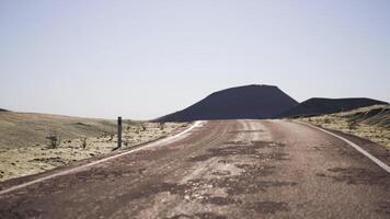 A winding road leads to distant hills in the Mongolian landscape at midday video