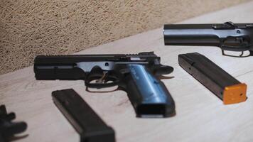 Man Choosing a Firearm from a Selection on Table video
