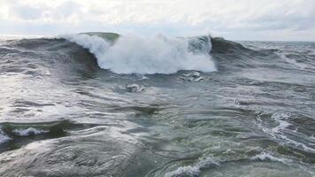 Powerful waves forming, breaking on the shore and splashing with white foam video