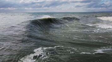 Powerful waves forming, breaking on the shore and splashing with white foam video