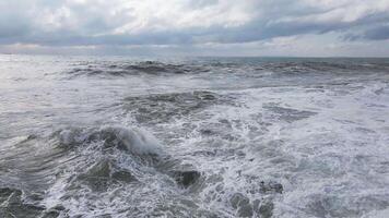 Powerful waves forming, breaking on the shore and splashing with white foam video