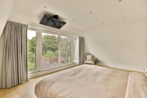 A bedroom with a bed, a tv, and a window photo