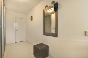 A hallway with a mirror and a bench photo