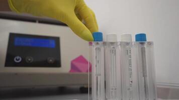 Test tubes are getting inserted into a biochemical analyzer by a lab worker video